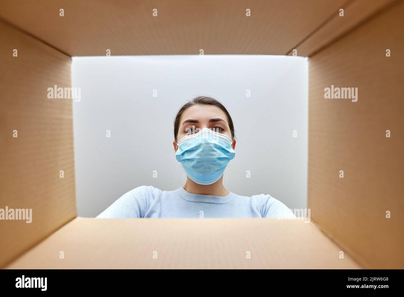 woman in mask looking inside cardboard parcel box Stock Photo - Alamy