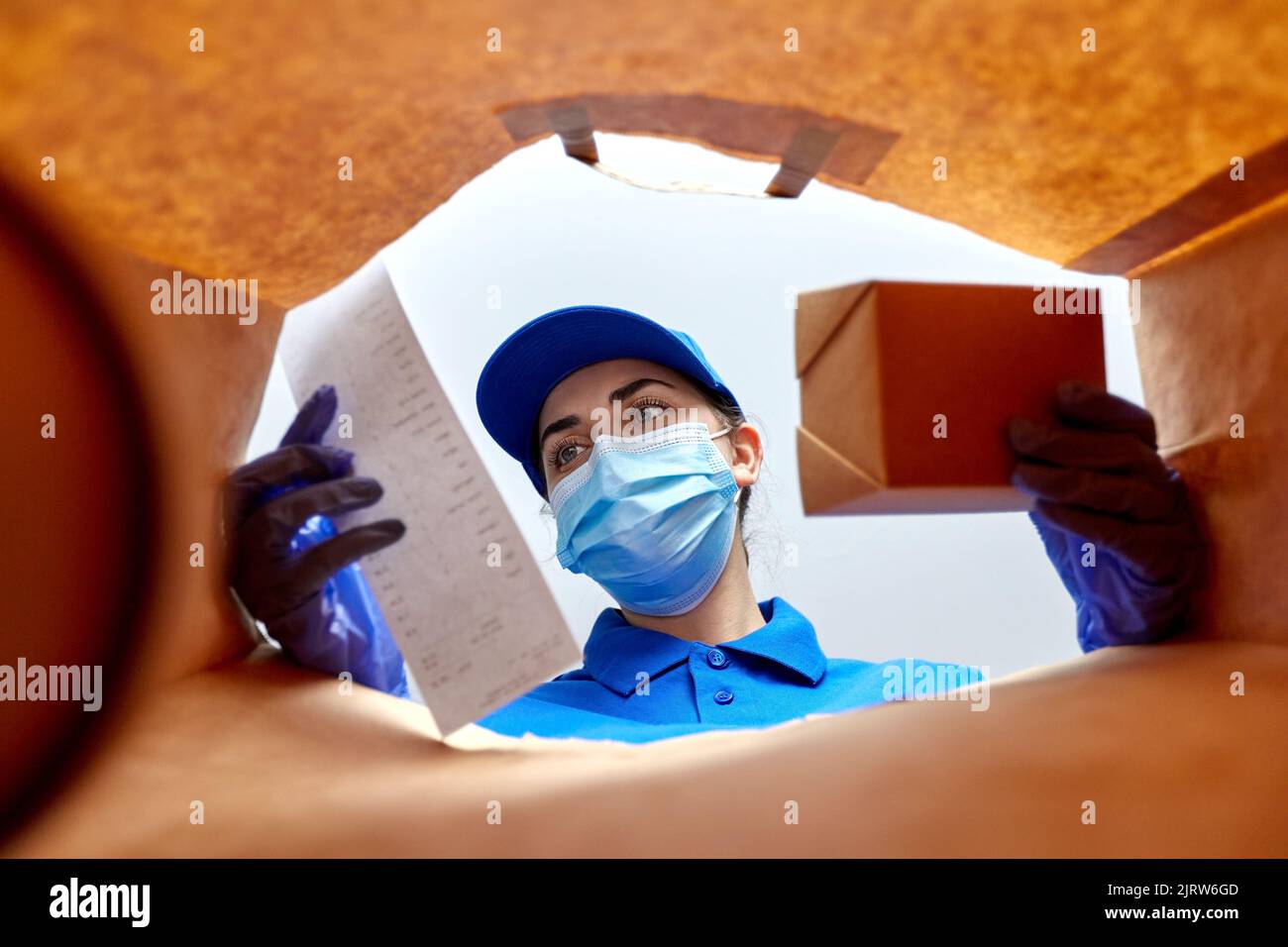 delivery girl in gloves and mask with food in bag Stock Photo - Alamy