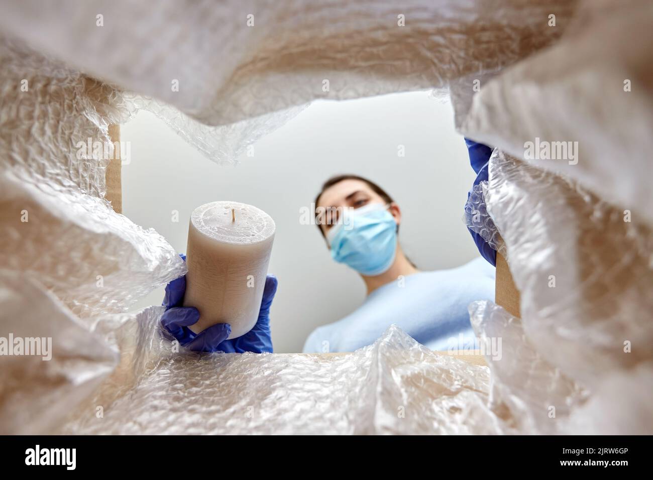 woman in mask packing candles into parcel box Stock Photo Alamy