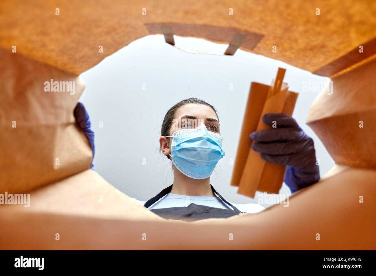 saleswoman in gloves and mask packing food in bag Stock Photo - Alamy