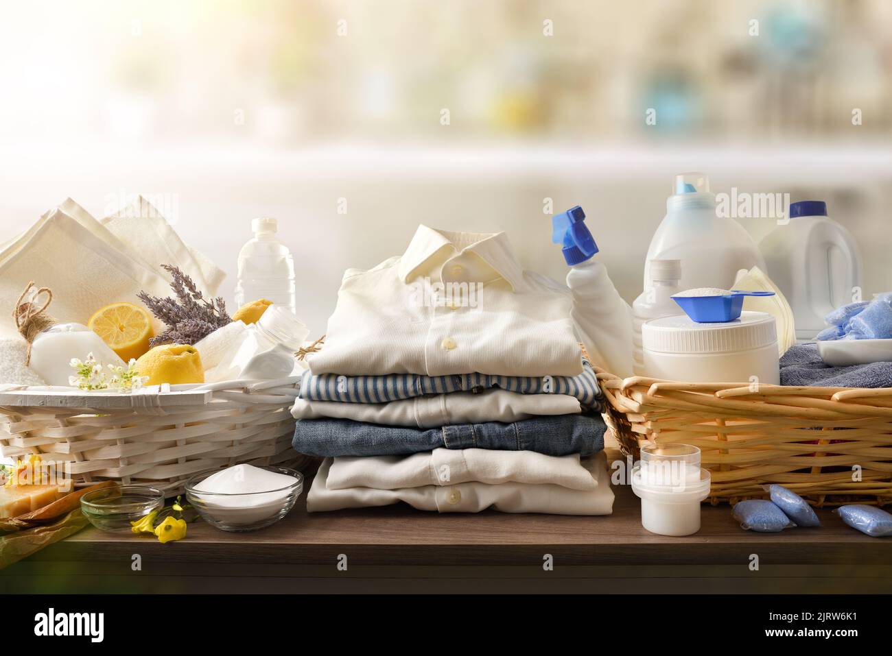 Detail comparison of ecological laundry cleaning products on wooden table and chemicals in domestic laundry. Front view. Horizontal composition. Stock Photo