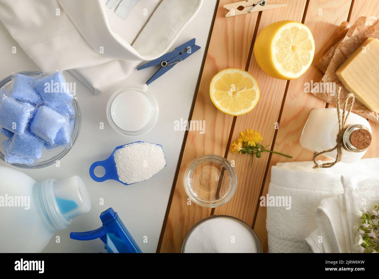 Detail comparison of ecological laundry cleaning products on wooden table and chemicals on white table. Top view. Horizontal composition. Stock Photo