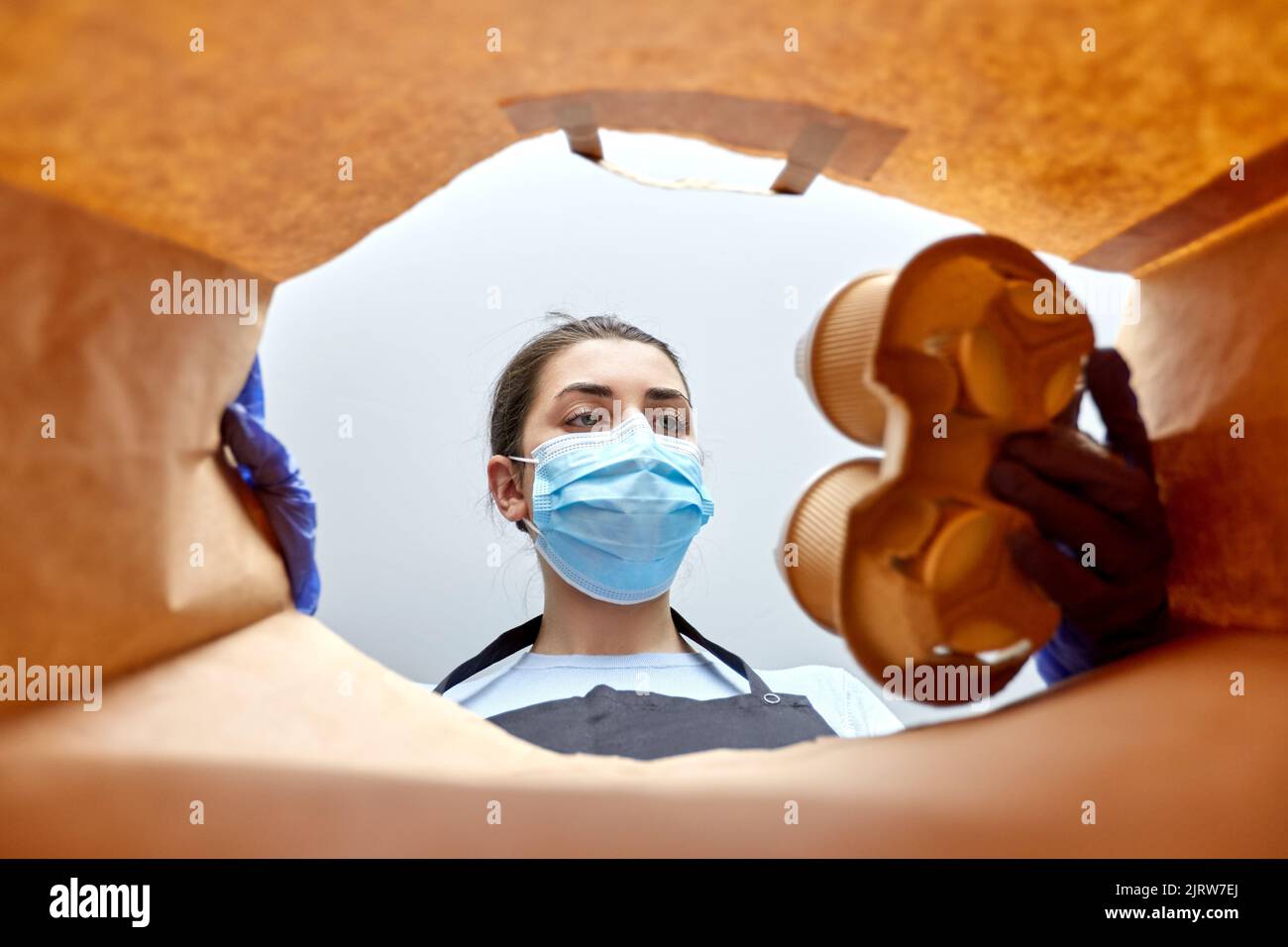 saleswoman in gloves and mask packing food in bag Stock Photo - Alamy