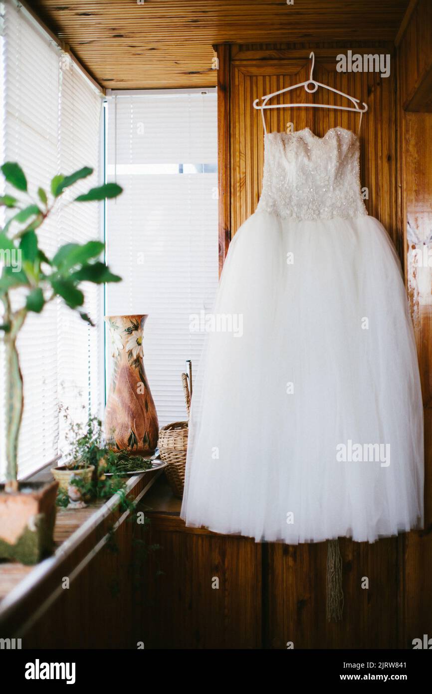 Wedding dress hanging on a wooden wardrobe Stock Photo - Alamy