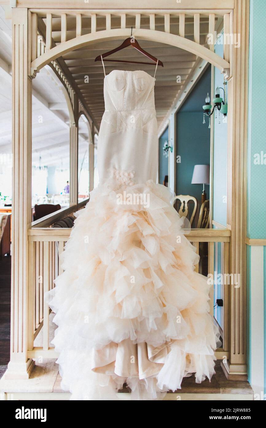 Wedding dress hanging on a wooden arch Stock Photo - Alamy