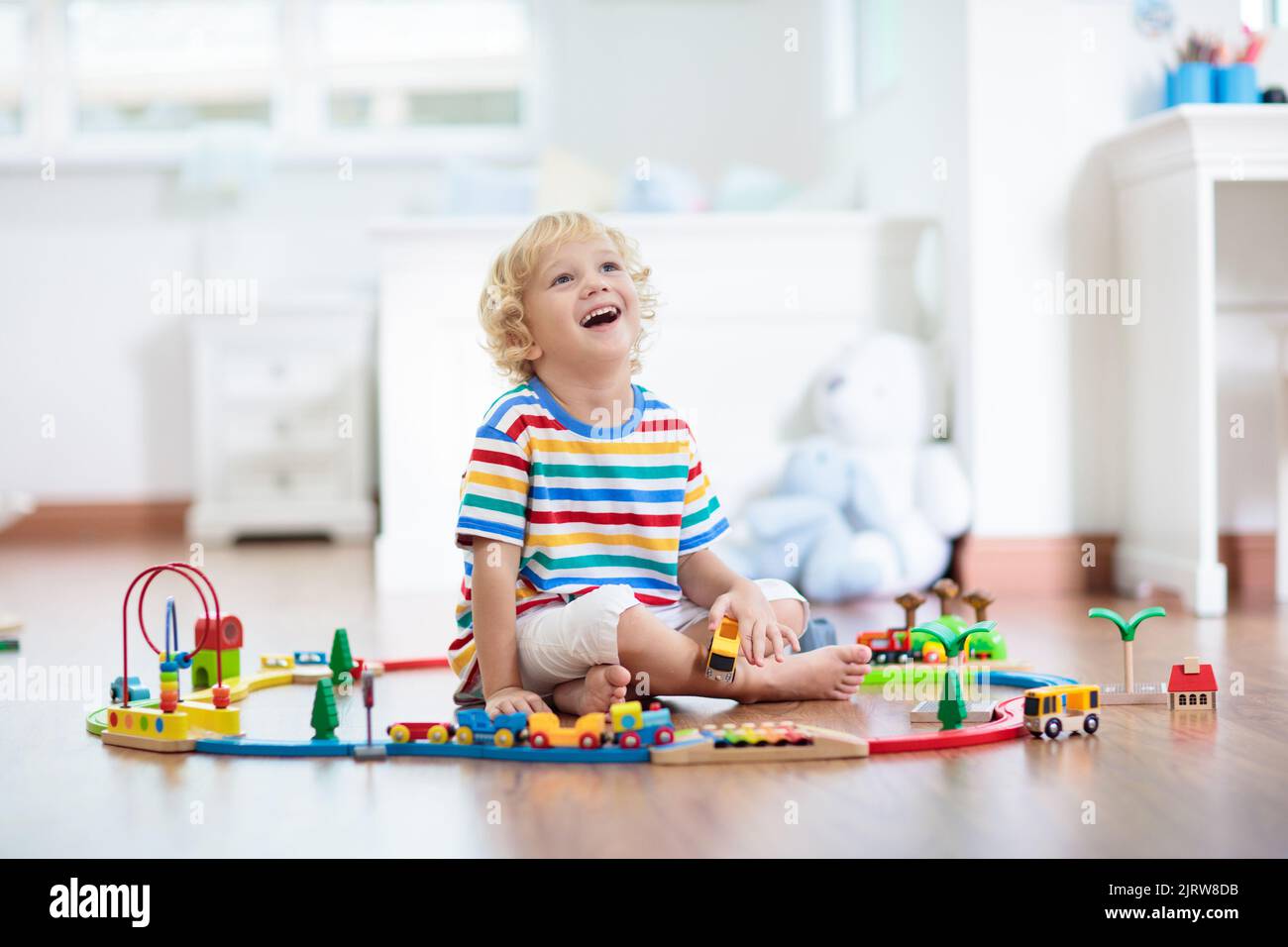 Kids play with wooden railway. Child with toy train. Educational toys