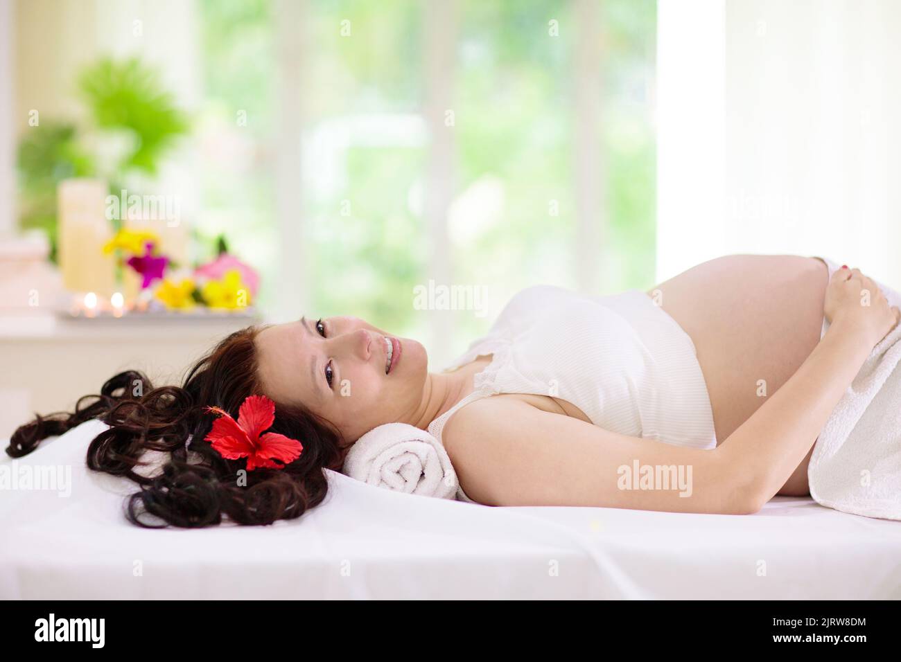 Pregnancy spa treatment. Massage for pregnant woman. Asian expectant mom enjoying wellness day