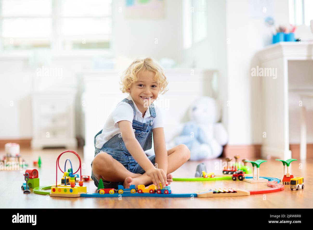 Kids play with wooden railway. Child with toy train. Educational toys