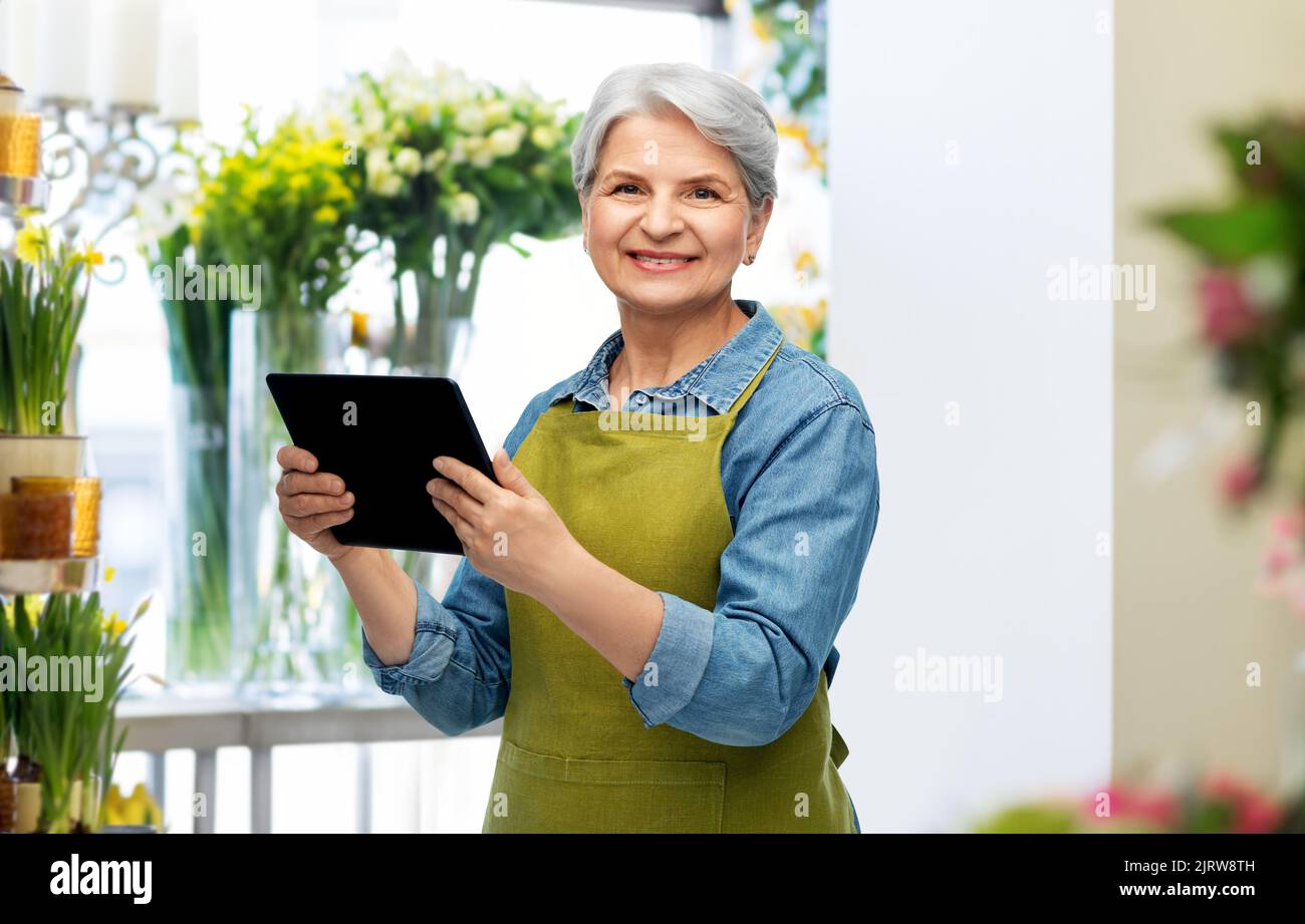 happy senior woman in garden apron with tablet pc Stock Photo - Alamy
