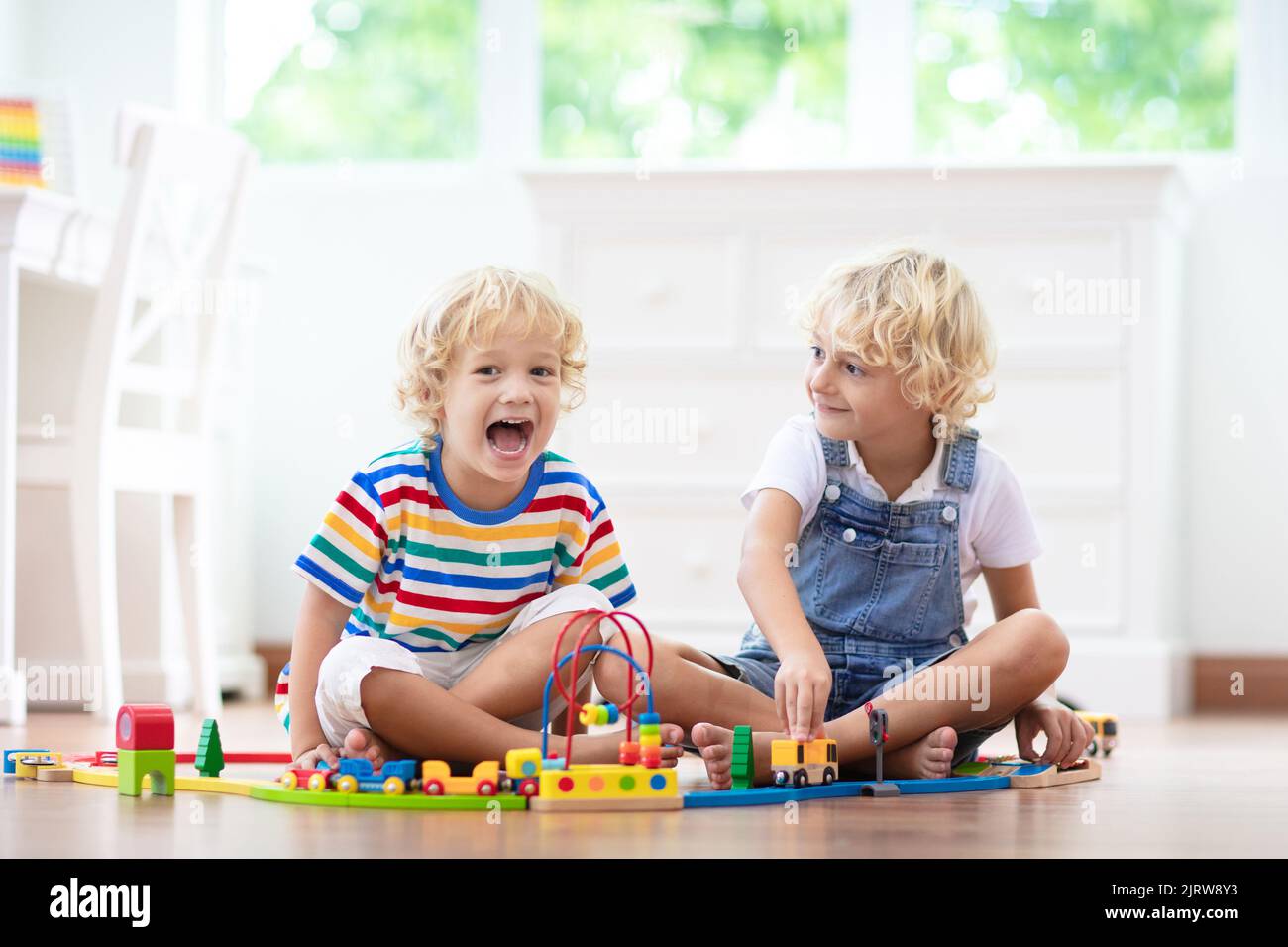 Kids play with wooden railway. Child with toy train. Educational toys