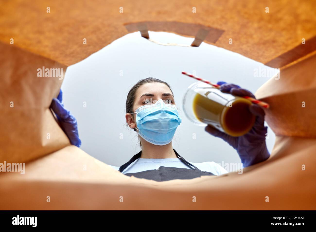 saleswoman in gloves and mask packing food in bag Stock Photo - Alamy
