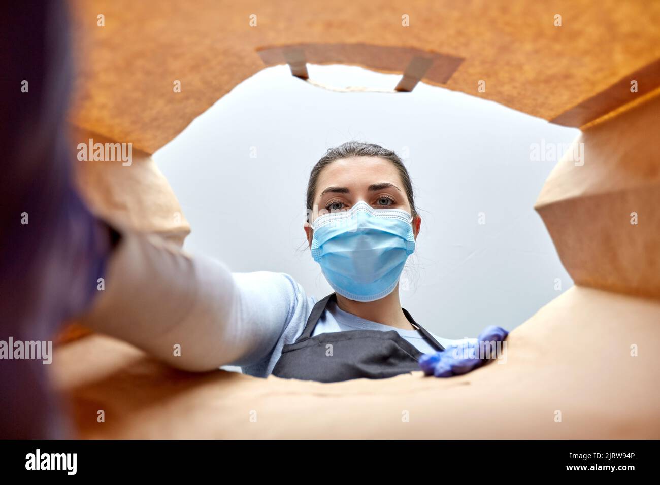 saleswoman in gloves and mask packing food in bag Stock Photo - Alamy