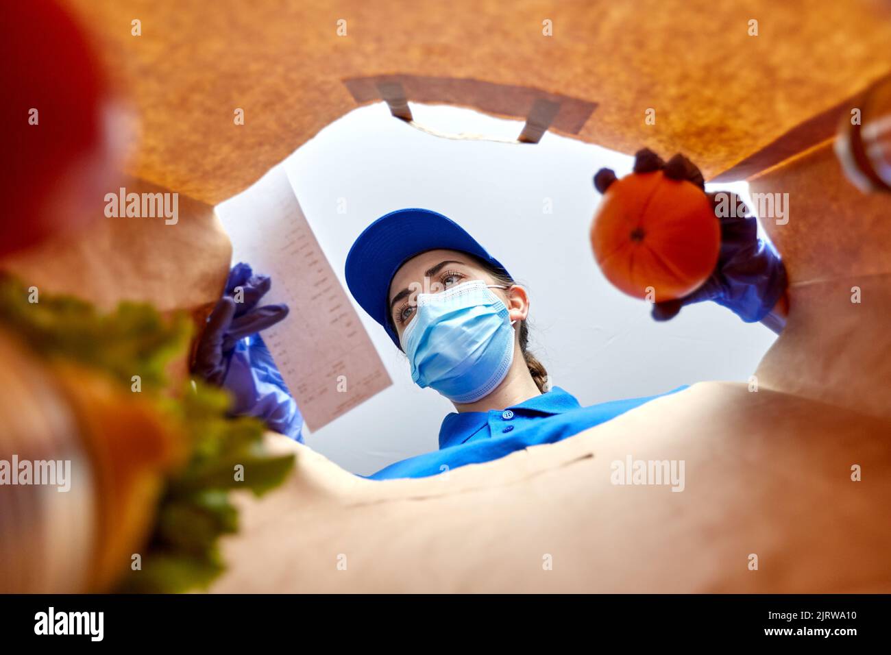delivery girl in gloves and mask with food in bag Stock Photo - Alamy