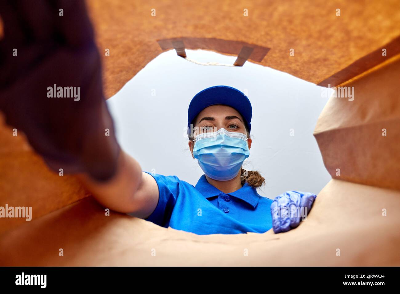 delivery girl in gloves and mask with food in bag Stock Photo - Alamy