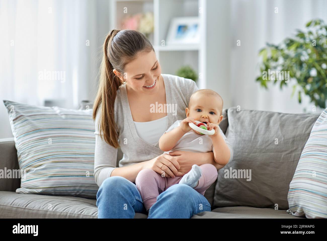 mother and little baby with teething toy at home Stock Photo