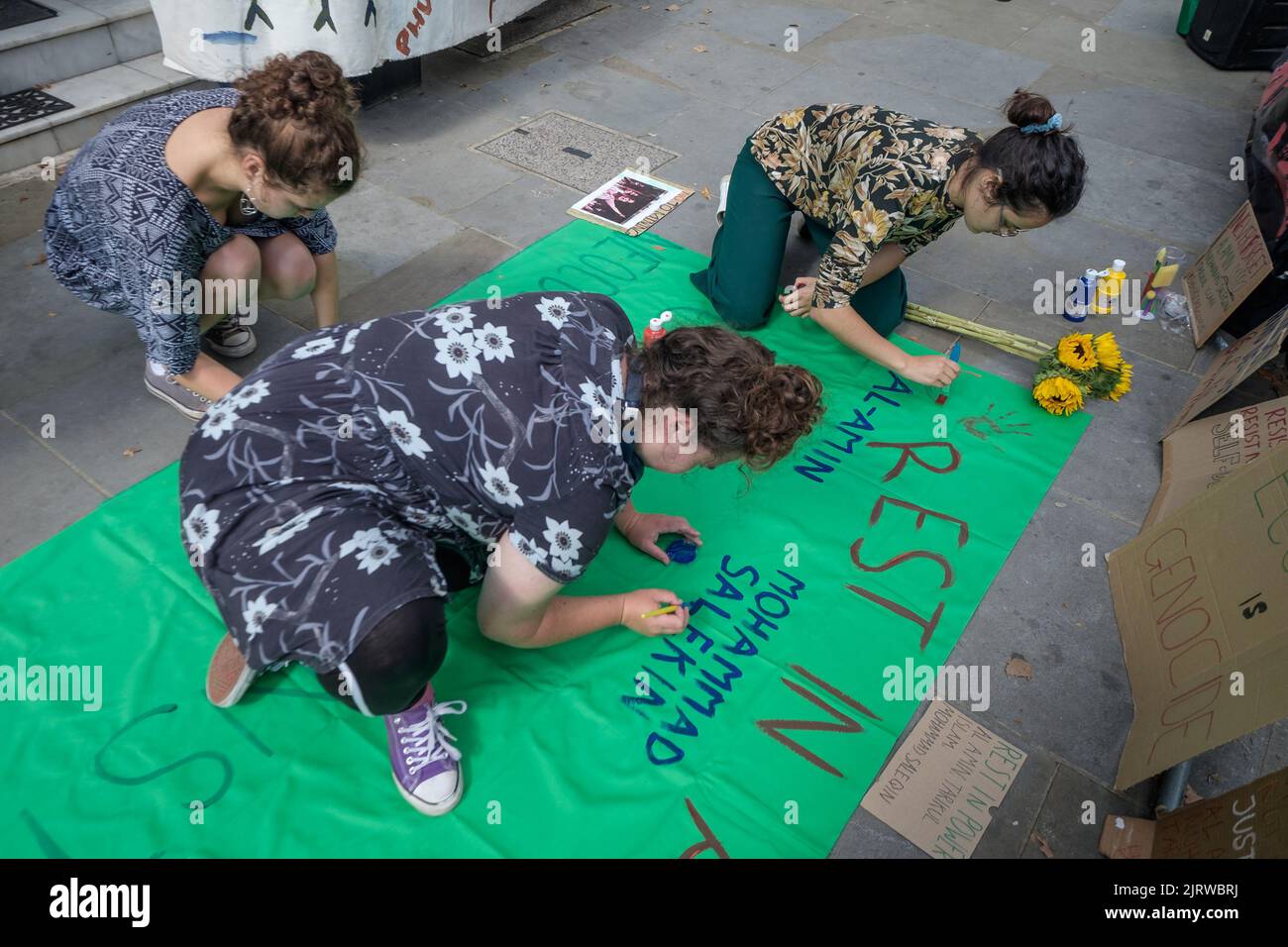London, UK. 26th Aug, 2022. People paint a tribute at Phulbari Solidarity Group vigil at the Bangladesh High Commission on the 16th anniversary of the Phulbari Massacre. 3 people were shot dead at a huge non-violent protest against London mining company GCM's plans to forcibly displace 130,000 people and open cast mine 572 million tons of coal over 30 years. GCM still sells shares on the London Stock Exchange despite having no contract to mine. Credit: Peter Marshall/Alamy Live News Stock Photo