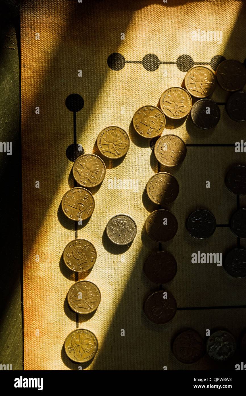 A vertical top view picture of Chinese coins on an old textured paper