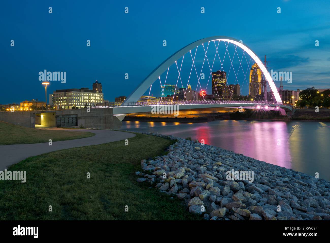 Iowa Women of Achievement Bridge at night reflected on the Des Moines River at Principal River Walk in Des Moines, Iowa Stock Photo