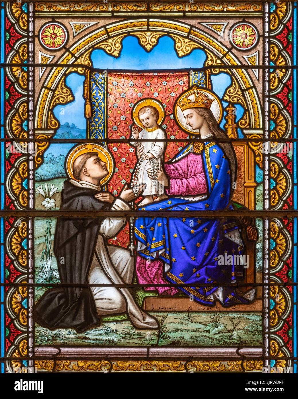 ALAGNA, ITALY - JULY 16, 2022: The Madonna presenting the Rosary to st. Dominic on the stained glass in the church San Giovanni Battista by J. Besnard Stock Photo