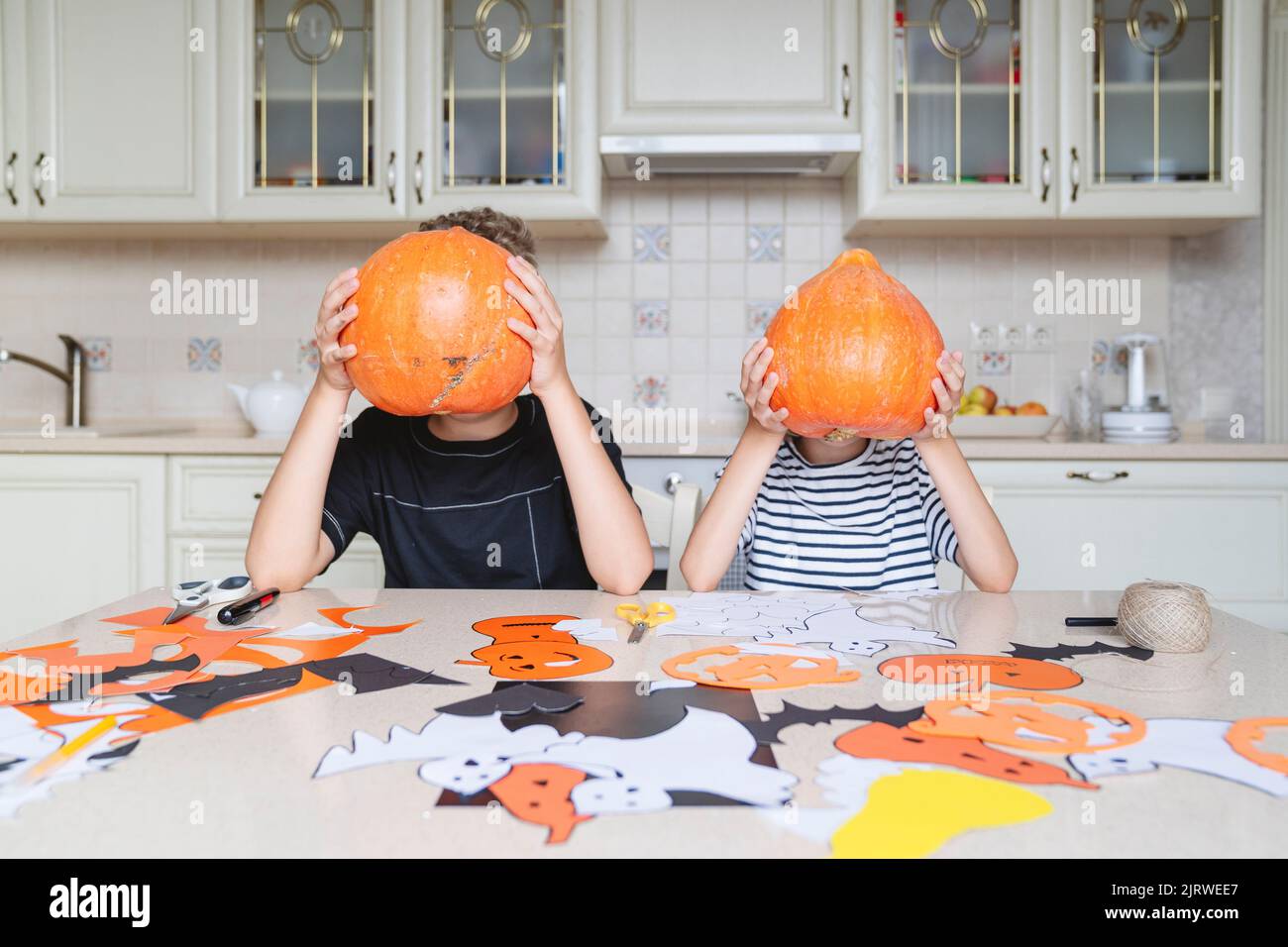 Children hold pumpkins and prepare for the Halloween holiday. Stock Photo