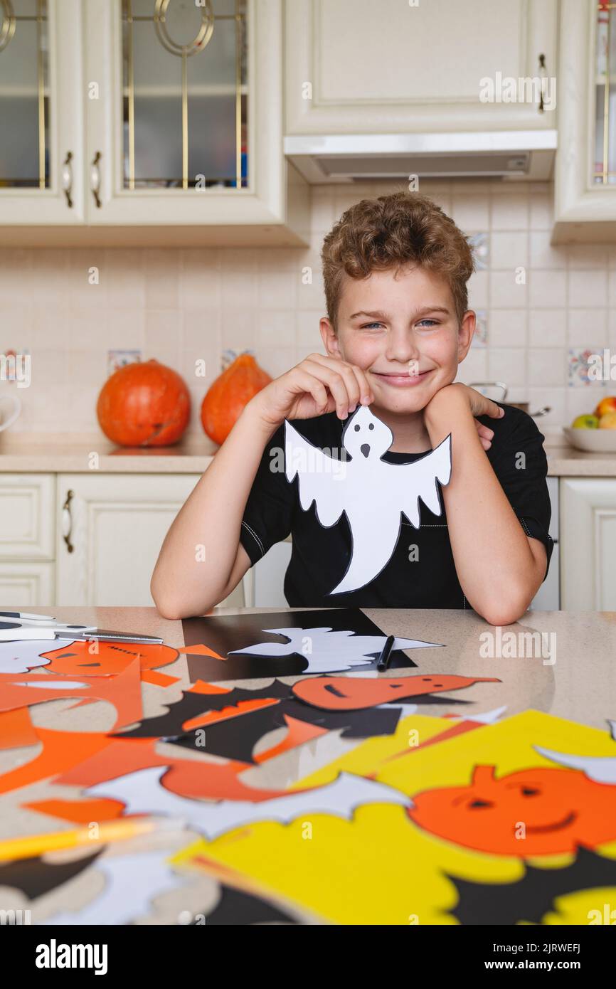Portrait of a boy with a ghost craft made of paper for Halloween. Stock Photo