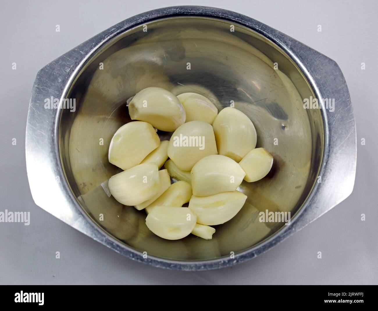 Whole peeled garlic cloves. Steel bowl. Studio set up Stock Photo Alamy