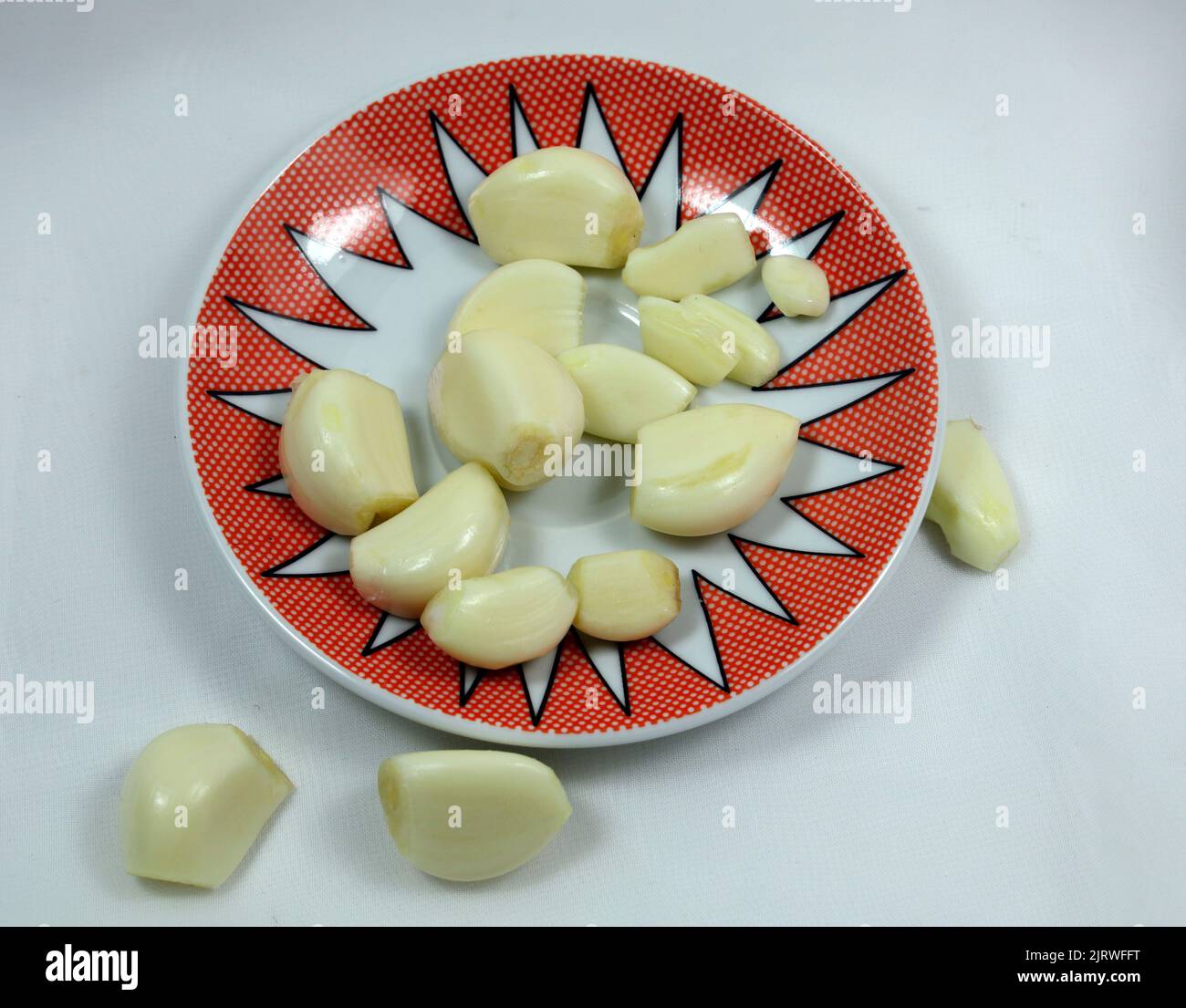 Whole peeled garlic cloves on a pretty saucer. Studio set up Stock ...