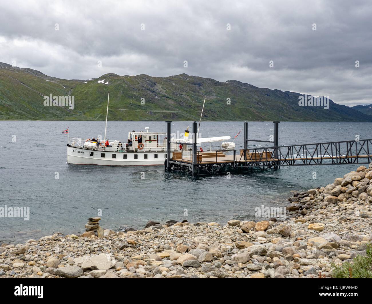 The ferry boat Bitihorn collecting passengers from the jetty at Torfinsbu on lake Bygdin in the Jotunheimen National Park Norway Stock Photo