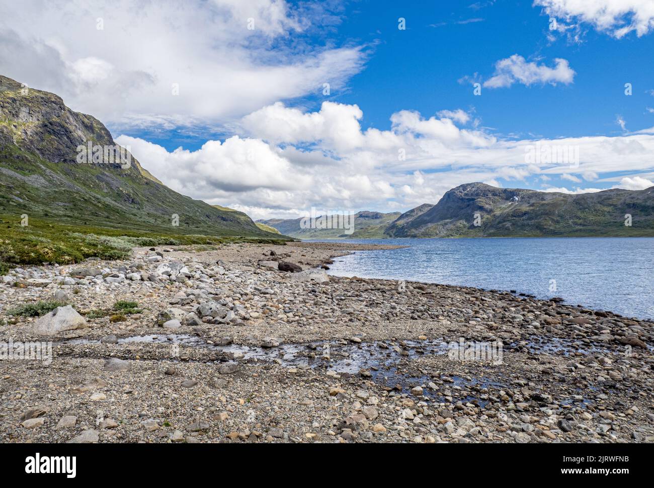 Looking along the shore of 25km long Lake Bygdin from its western end near Eidsbugarden in the Jotunheimen National Park Norway Stock Photo