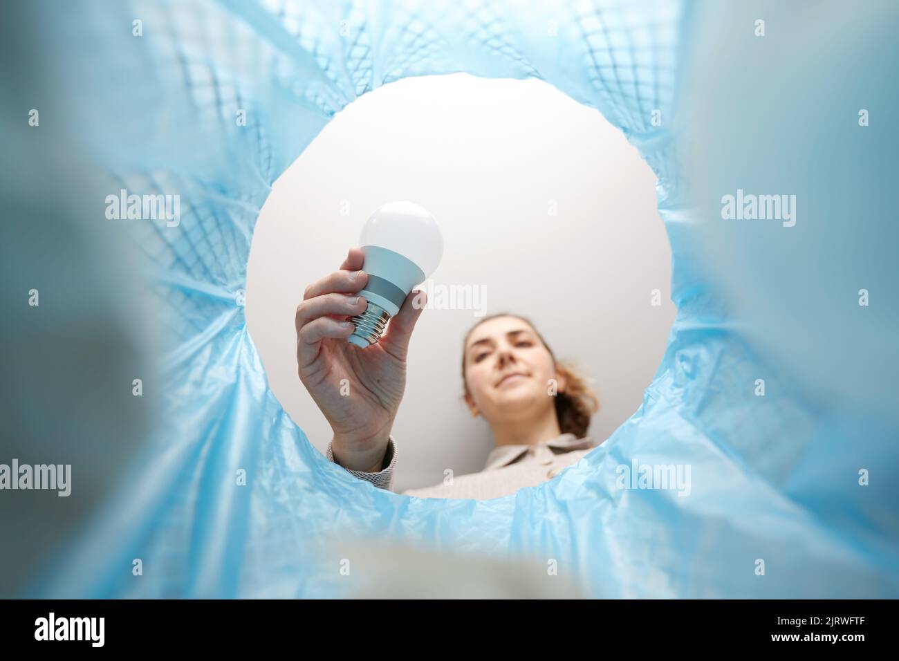 woman throwing light bulb into trash can Stock Photo - Alamy