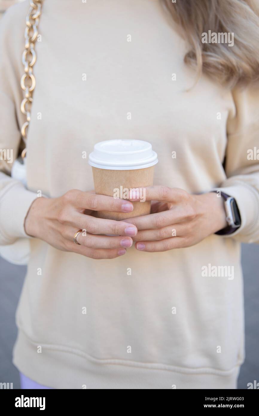 A cup of coffee in girl hands on the background of hoodie Stock Photo ...