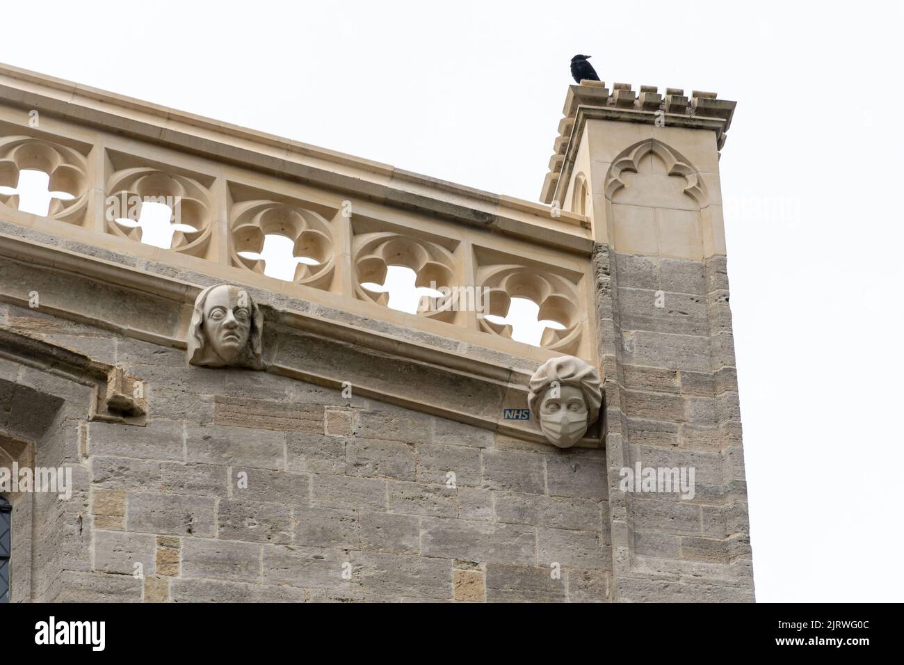 A stone carving of a mask-wearing NHS worker on Christchurch Priory, a new gargoyle on the historic building as a tribute, Dorset, England, UK Stock Photo