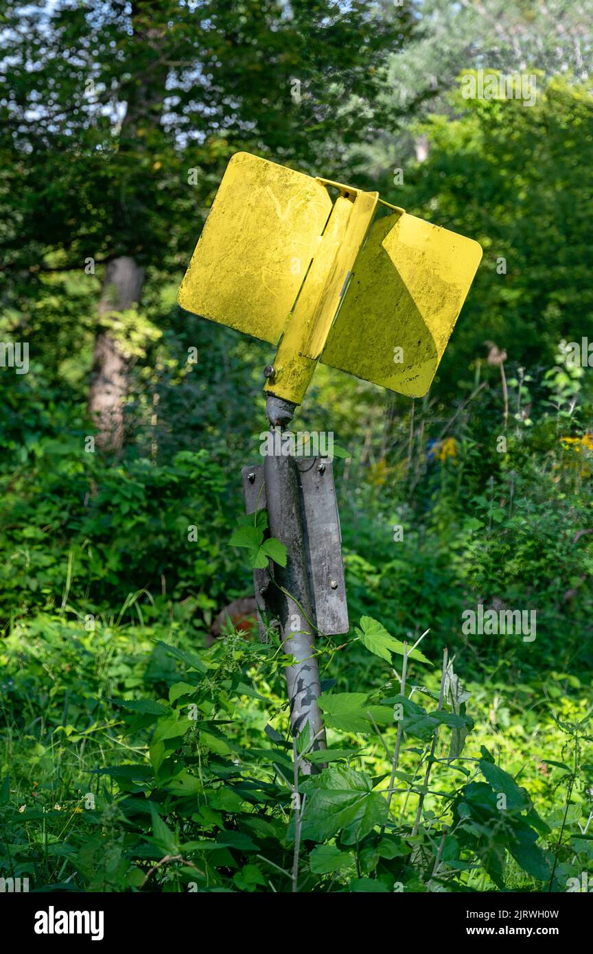 bent yellow sign of an underground gas line in a forest at Tulln, Austria Stock Photo