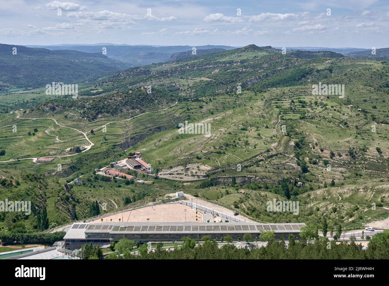 aerial view of the soccer field on the Morella mountain with a line of horizontal axis wind turbines on the horizon line, Castellon, Spain, Europe Stock Photo