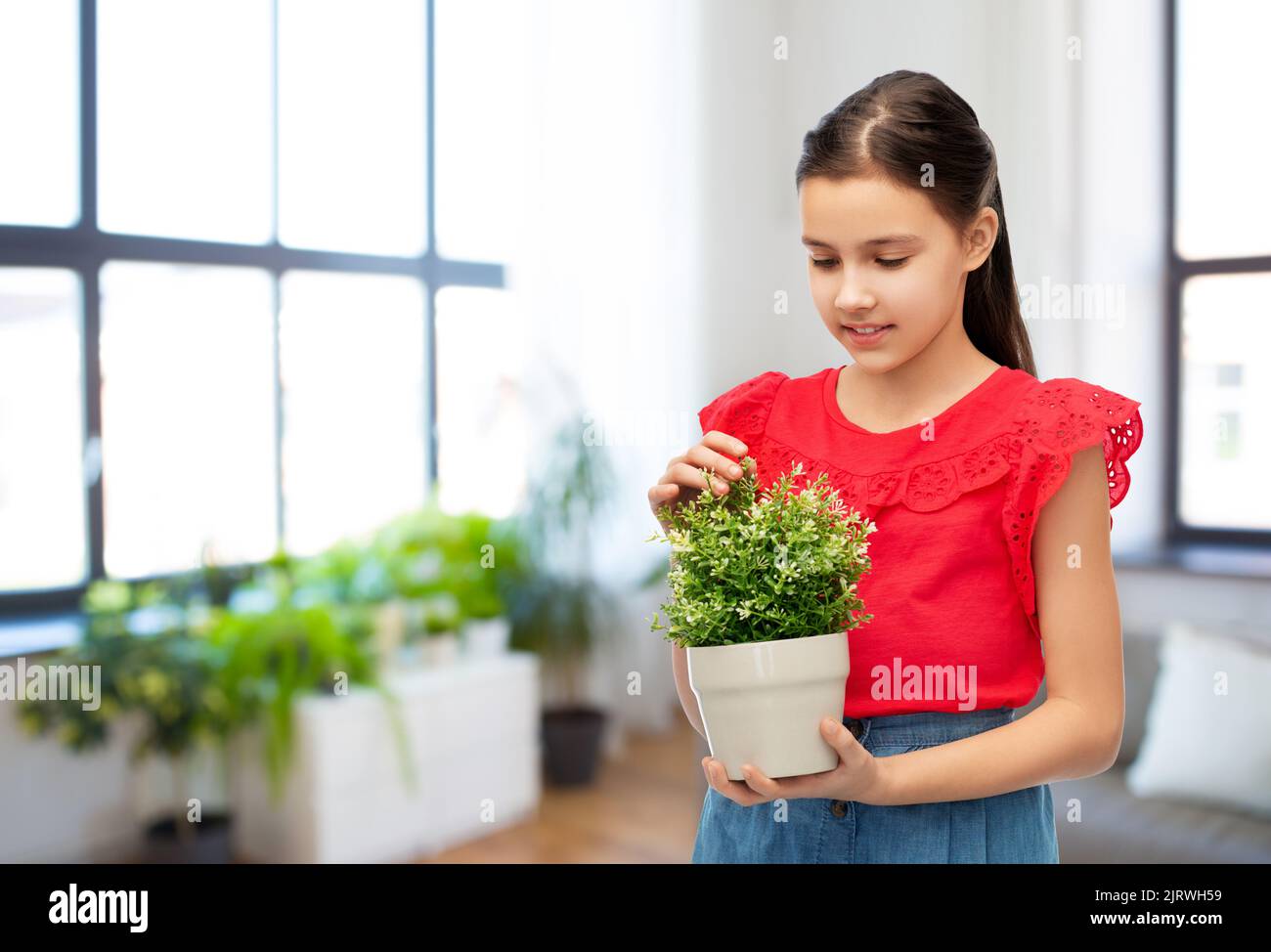 happy smiling girl holding flower in pot Stock Photo - Alamy