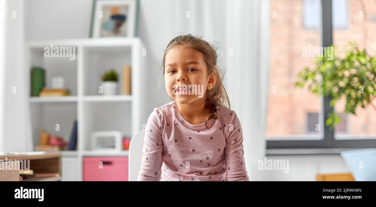happy smiling little girl sitting on chair at home Stock Photo - Alamy