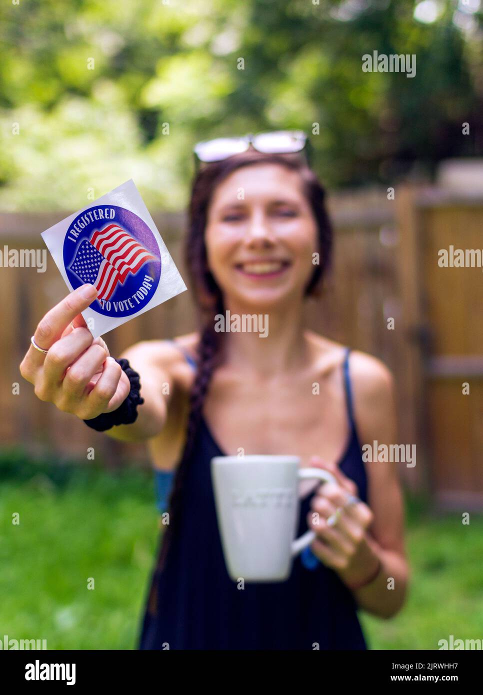 A young woman holds a voter registration sticker, as the Supreme Court's Dobbs decision creates a surge of newly registered voters across the US Stock Photo