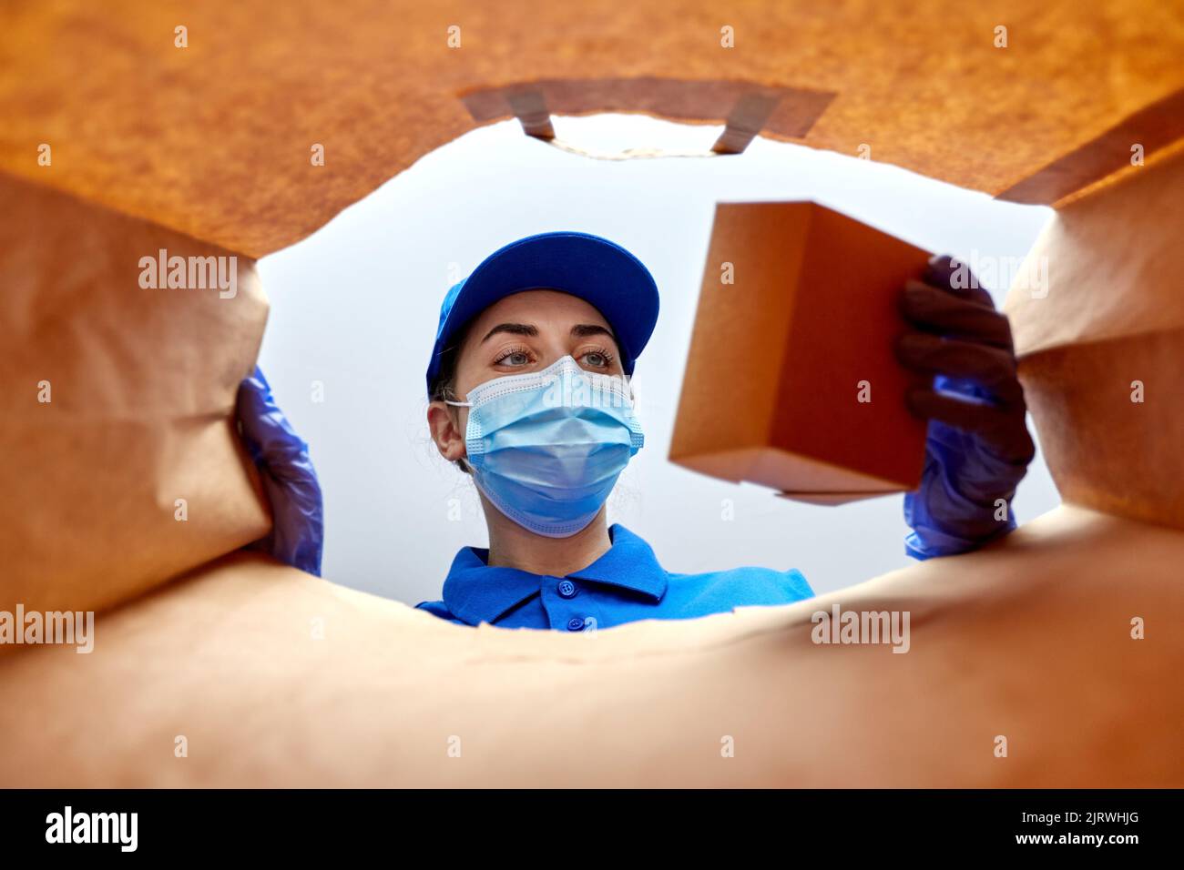 delivery girl in gloves and mask with food in bag Stock Photo - Alamy