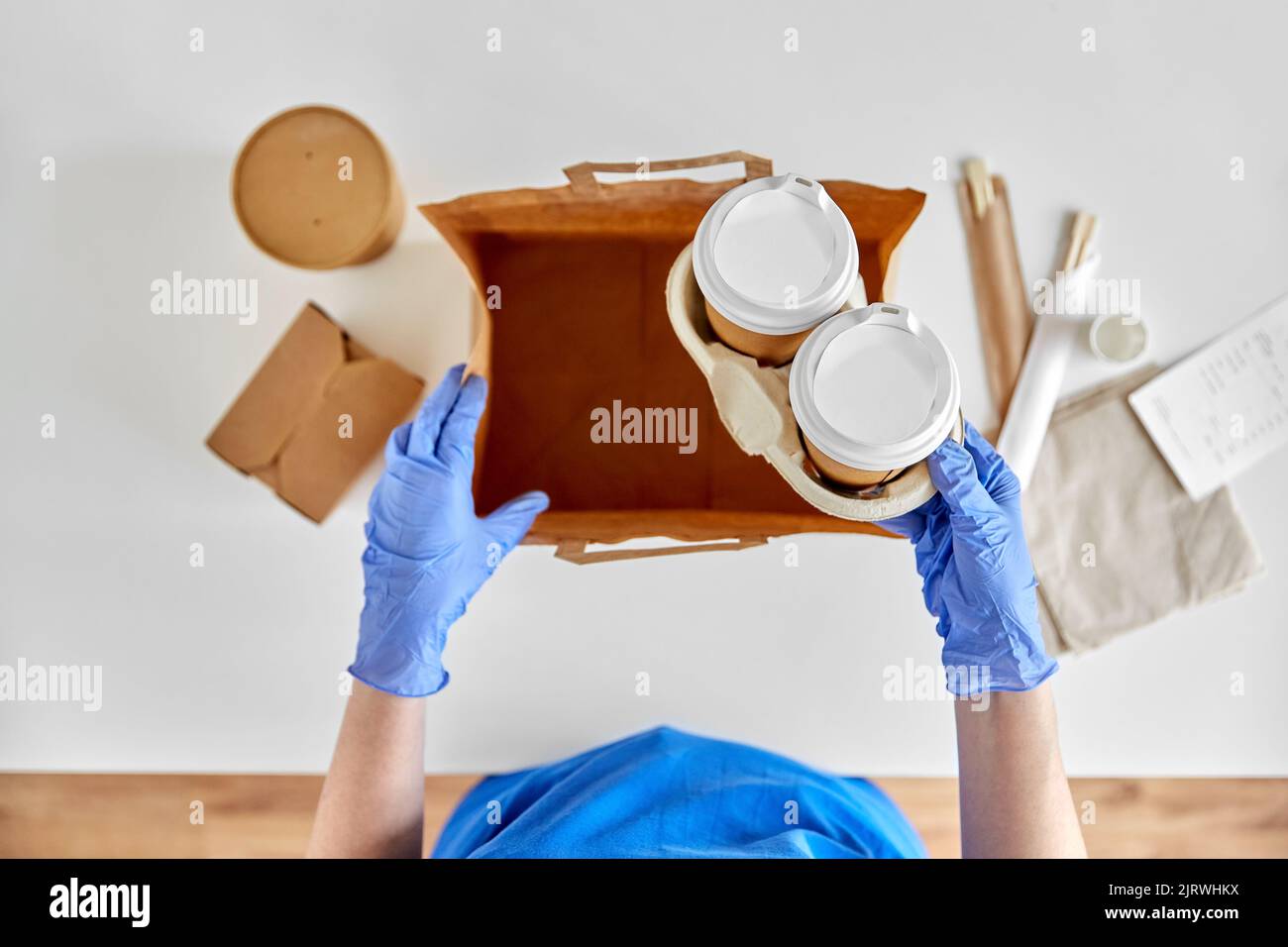 delivery woman in gloves packing food and drinks Stock Photo - Alamy