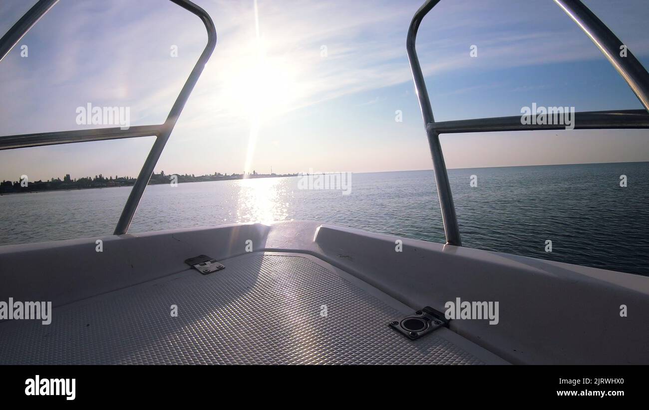 Seascape, view of sea waves with sun reflection from prow of motorboat. Boat jumping on waves on sunny summer day. Yacht motor boat sailing fast at sea horizon. Extreme sport entertainment background Stock Photo