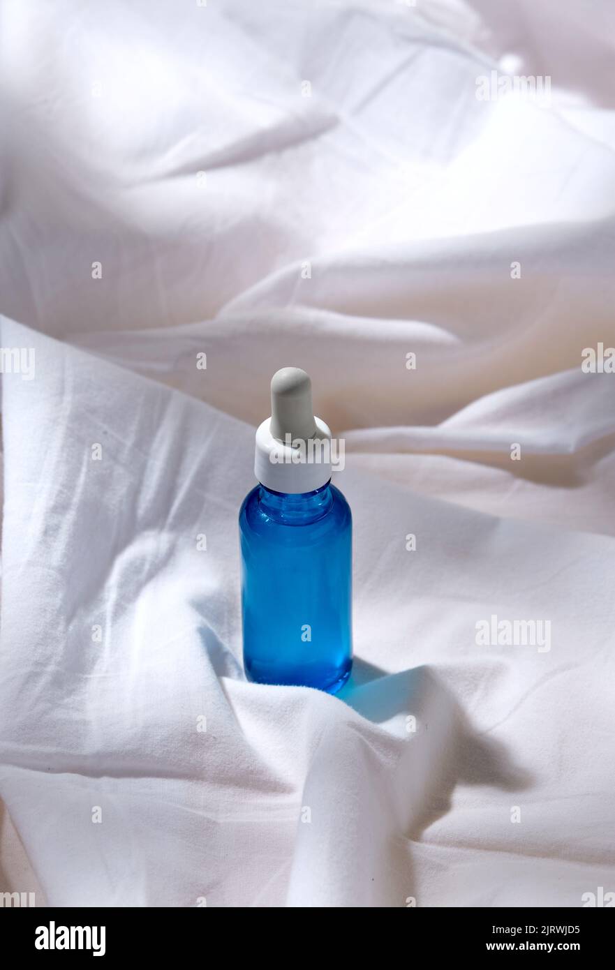 bottle of serum on white sheet Stock Photo Alamy