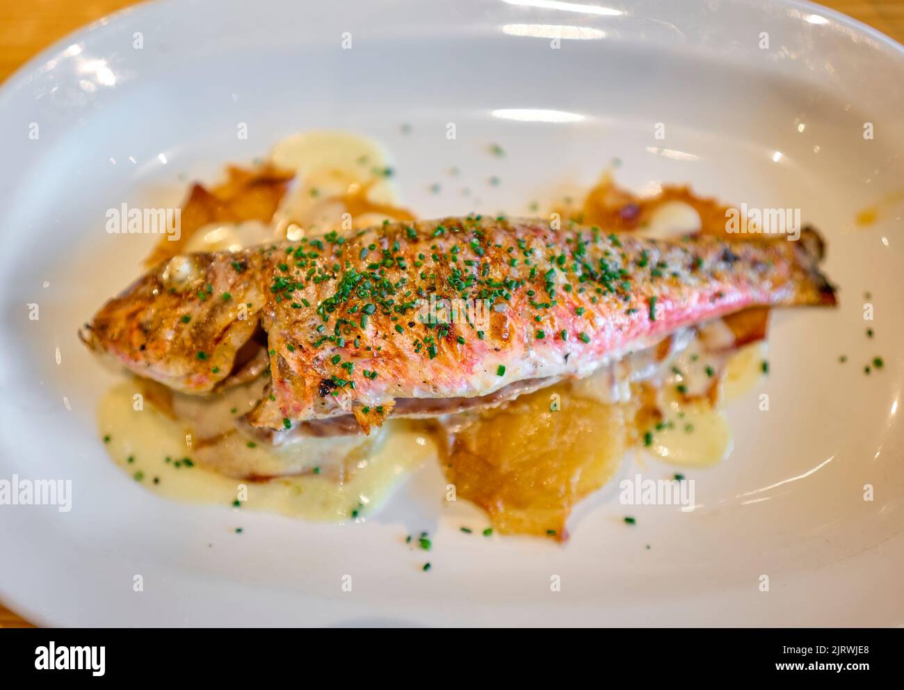 Grilled Red Mullet serverd over baked potatoes. Stock Photo