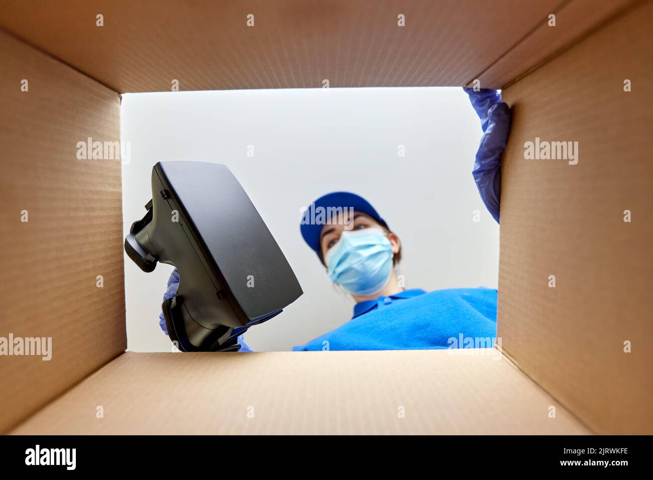 woman in mask packing vr glasses to parcel box Stock Photo - Alamy