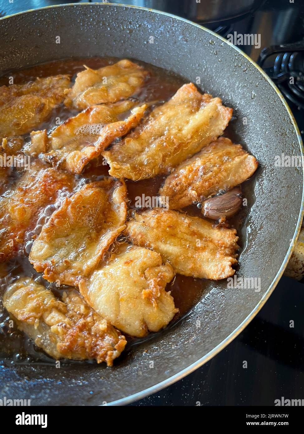 Fish being fried in a pan with oil. Fried food. Stock Photo