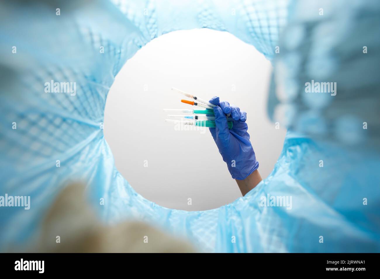 hand throwing used syringes into trash can Stock Photo Alamy