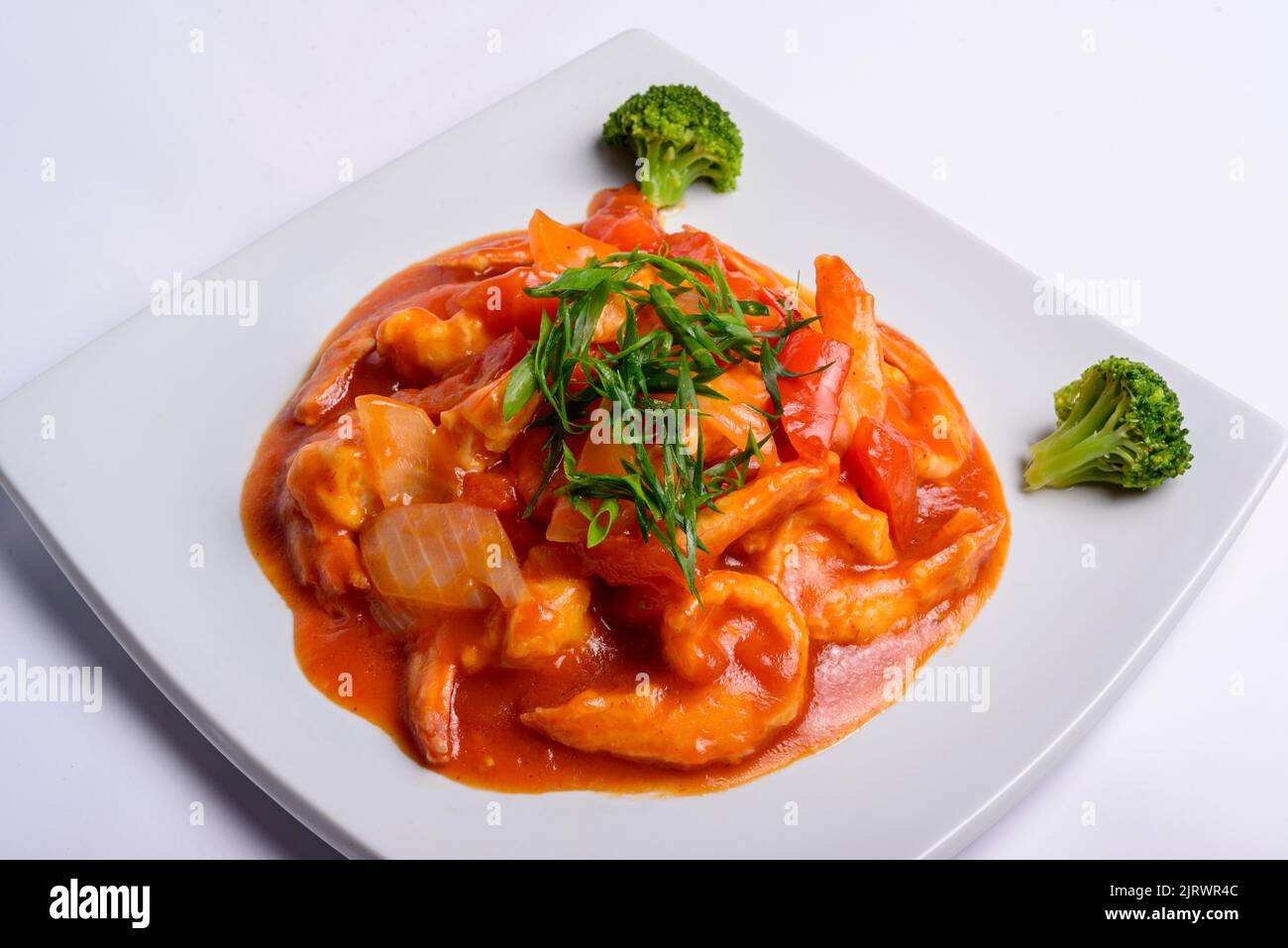 Shrimp in tomato sauce on a white square plate. Closeup. Chinese food