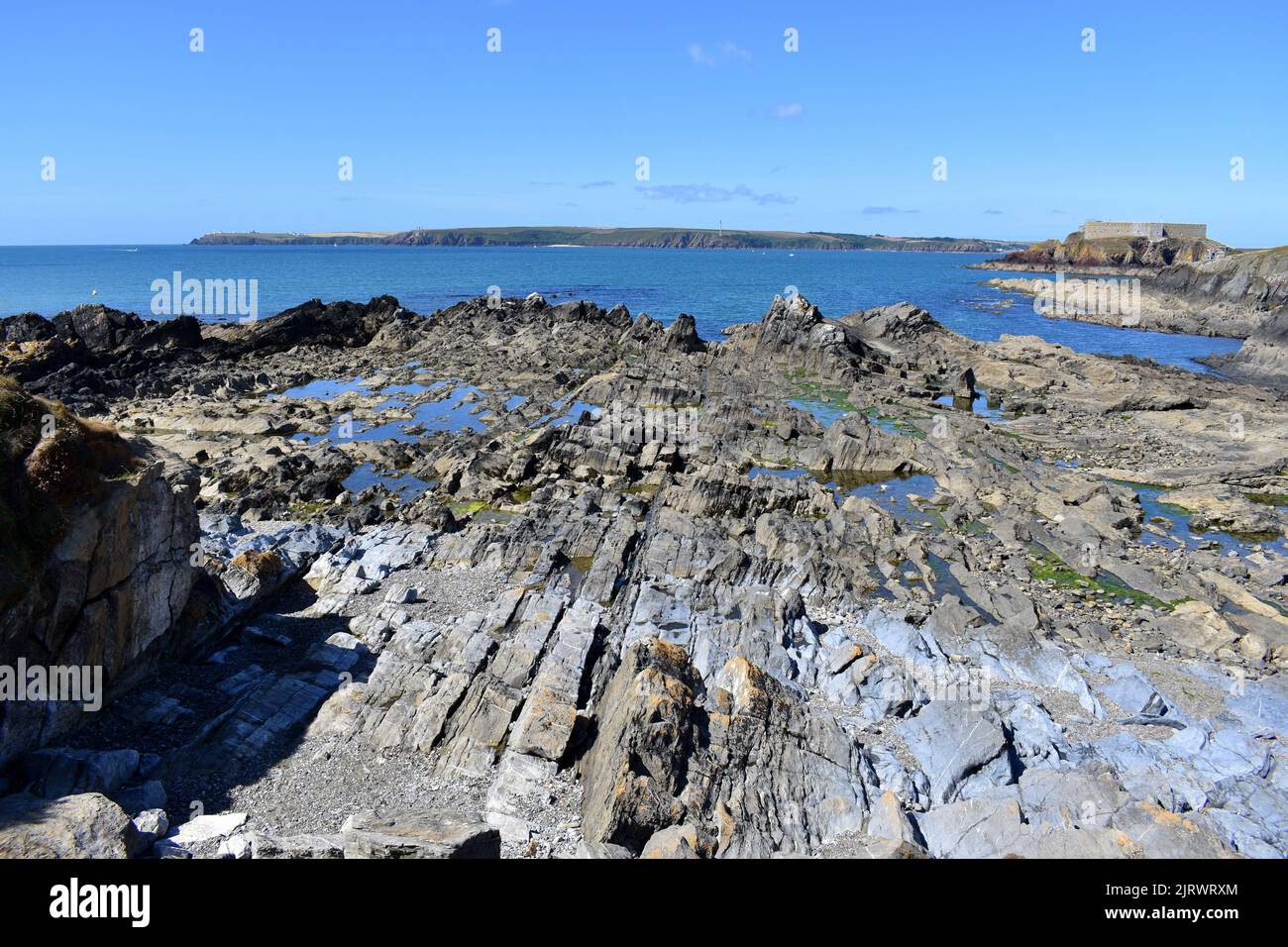 Rocky outcrop and Thorne island, West Angle Bay, Pembrokeshire, Wales Stock Photo