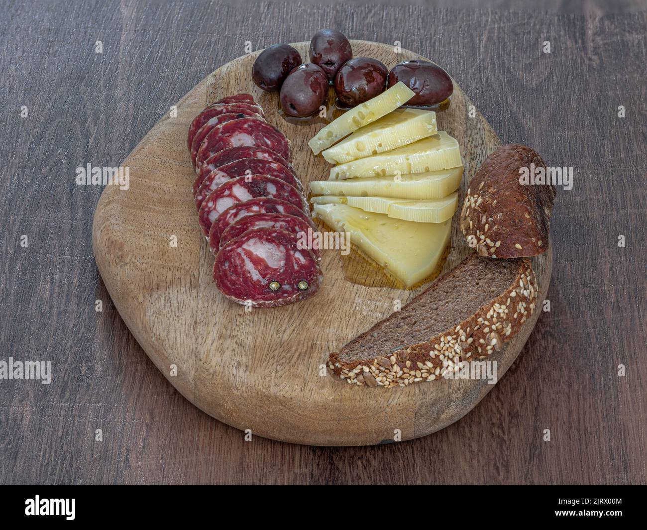 traditional homemade Istrian salami sausage with cheese olives and brown bread on wood tray stock photo Stock Photo