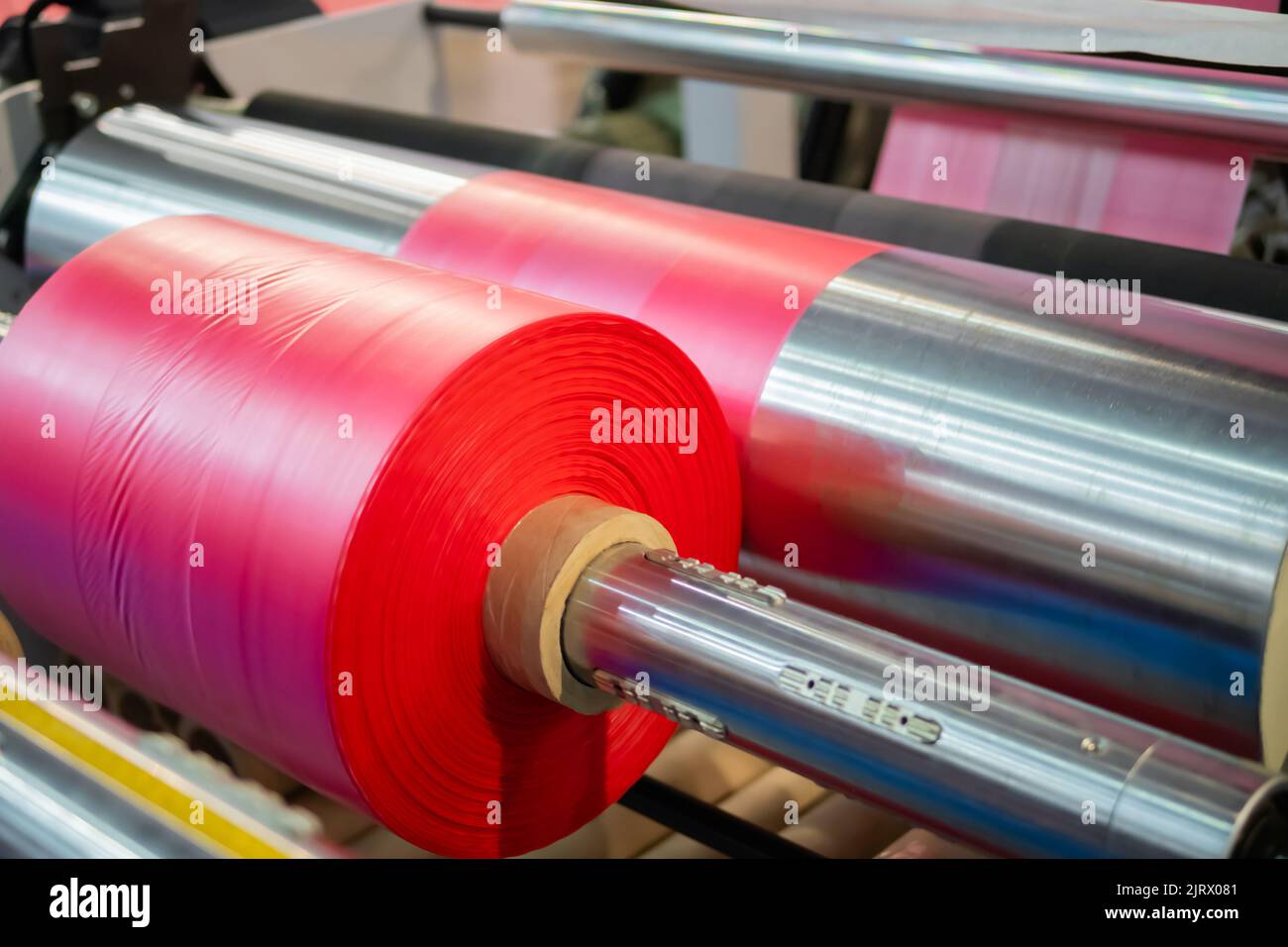 Automatic plastic bag making machine: moving roller with pink film at trade show Stock Photo