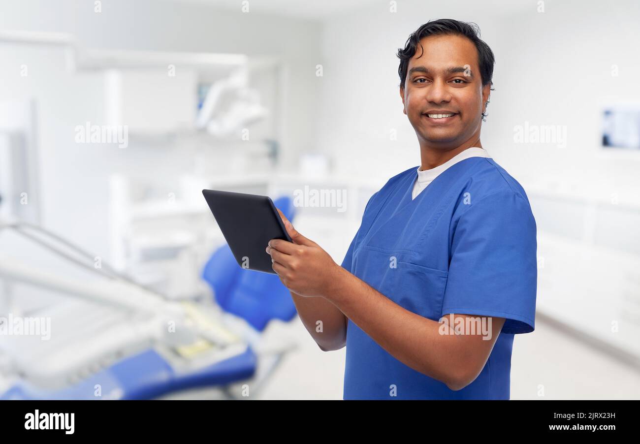 smiling doctor using tablet pc at dental office Stock Photo